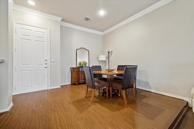 dining space featuring hardwood / wood-style flooring and ornamental molding