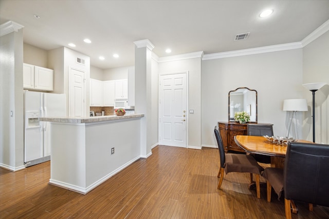 kitchen featuring white cabinetry, ornamental molding, white appliances, and light hardwood / wood-style floors