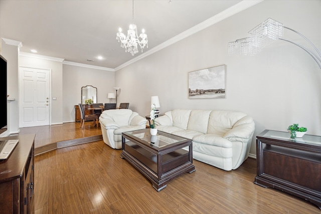 living room featuring wood-type flooring, a notable chandelier, and crown molding