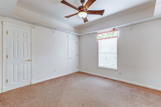 spare room featuring light colored carpet and ceiling fan