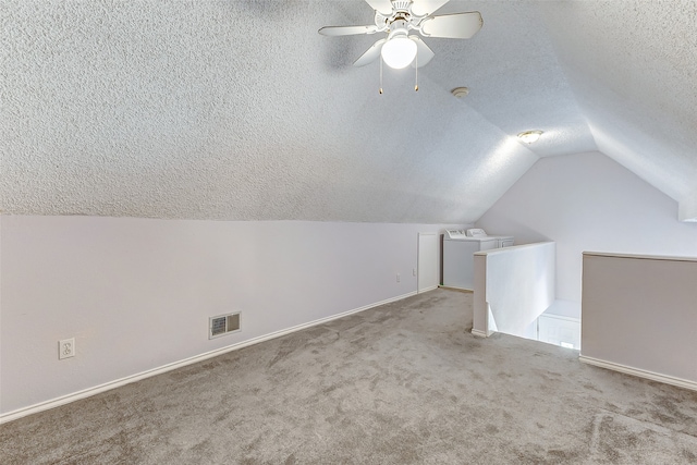 additional living space featuring lofted ceiling, ceiling fan, carpet, and a textured ceiling