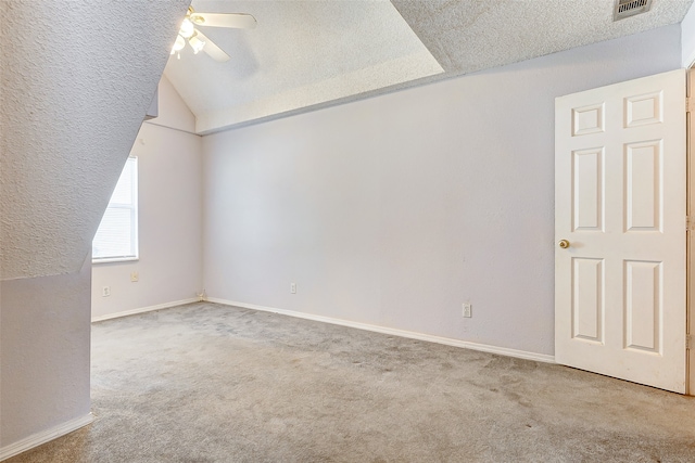 bonus room with lofted ceiling, light colored carpet, ceiling fan, and a textured ceiling