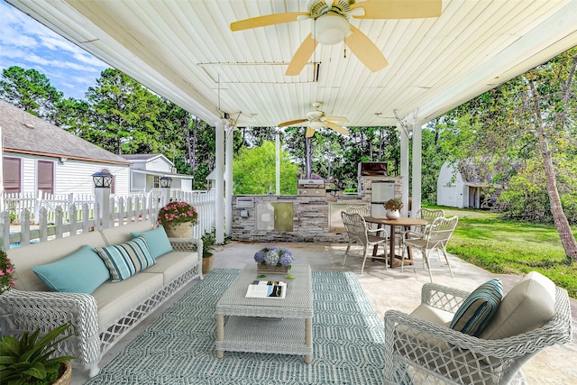 view of patio with area for grilling, outdoor lounge area, ceiling fan, and a storage shed