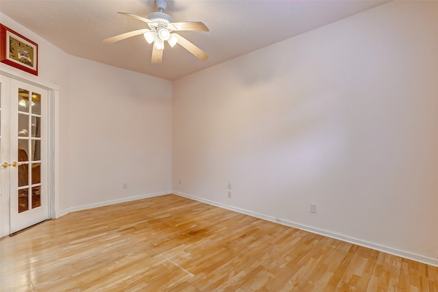 empty room featuring french doors, light wood-type flooring, and ceiling fan