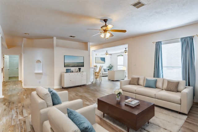 living room with ceiling fan and light hardwood / wood-style flooring