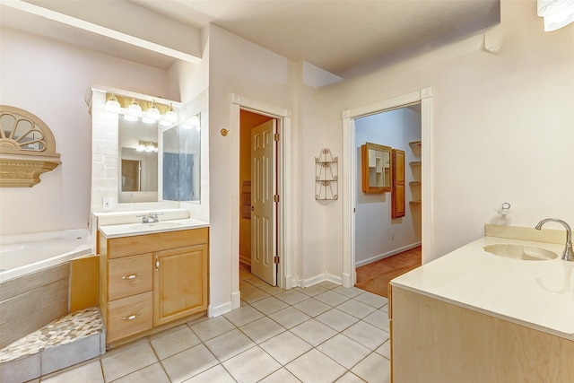 bathroom featuring a relaxing tiled tub, tile patterned flooring, and vanity