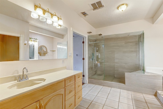 bathroom with vanity, separate shower and tub, tile patterned flooring, and a textured ceiling