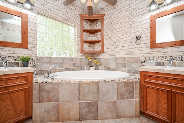 bathroom featuring vanity, a relaxing tiled tub, and ceiling fan