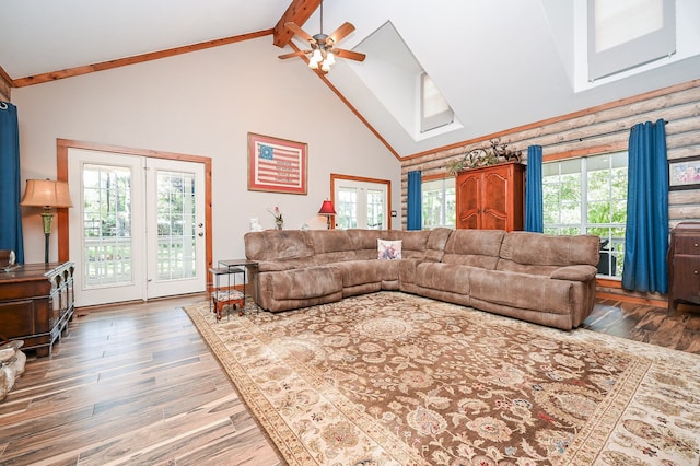 living room with a wealth of natural light, ceiling fan, dark hardwood / wood-style floors, and beamed ceiling