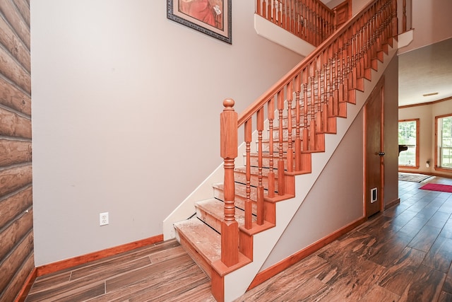 stairway featuring wood-type flooring and ornamental molding