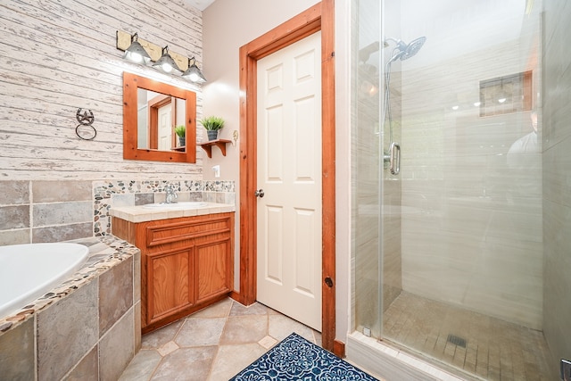 bathroom with tile patterned flooring, vanity, and plus walk in shower