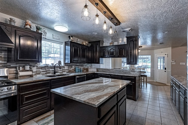 kitchen featuring stainless steel stove, a healthy amount of sunlight, and a kitchen island