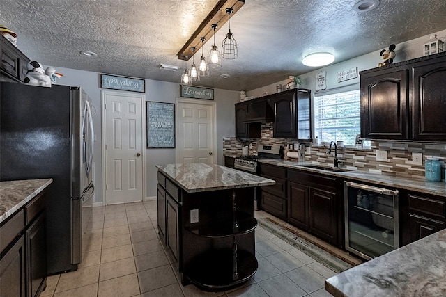 kitchen with hanging light fixtures, wine cooler, backsplash, stainless steel appliances, and a center island