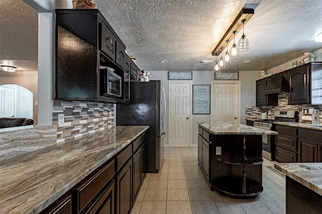 kitchen featuring light stone countertops, a textured ceiling, and appliances with stainless steel finishes