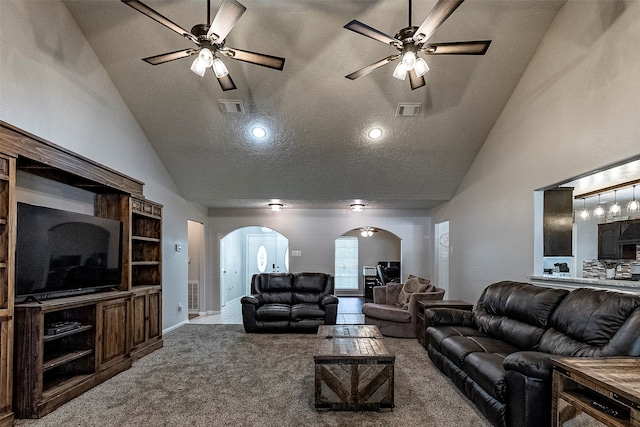 living room with high vaulted ceiling, carpet, ceiling fan, and a textured ceiling