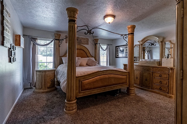 bedroom featuring multiple windows, a textured ceiling, and dark carpet