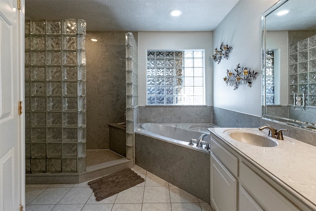 bathroom with shower with separate bathtub, tile patterned flooring, a textured ceiling, and vanity