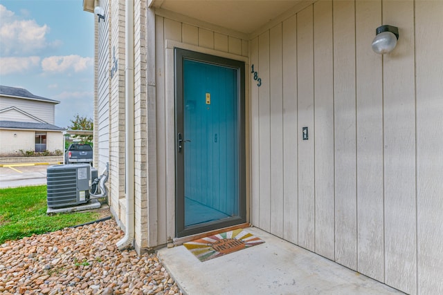 view of exterior entry featuring central air condition unit