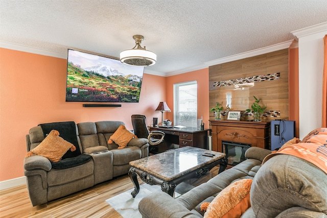 living room with a textured ceiling, light hardwood / wood-style flooring, and ornamental molding