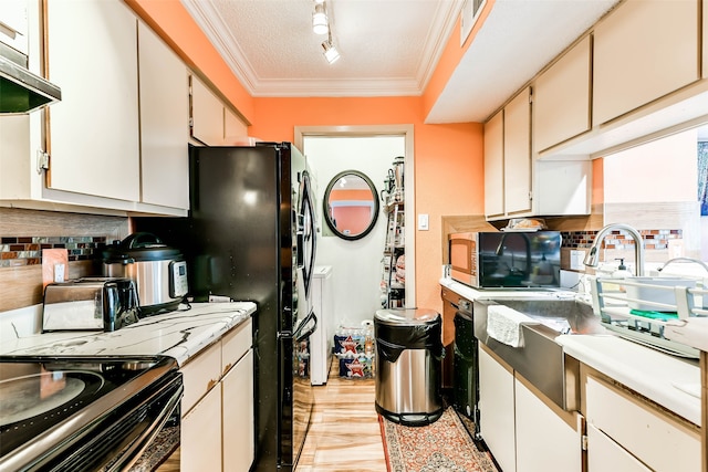 kitchen with appliances with stainless steel finishes, light hardwood / wood-style floors, white cabinetry, exhaust hood, and a textured ceiling