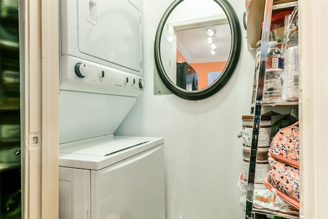 clothes washing area featuring stacked washer and clothes dryer