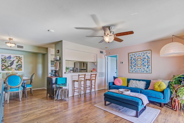 living room featuring light hardwood / wood-style floors and ceiling fan