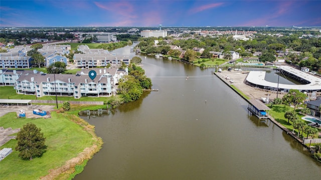 aerial view at dusk featuring a water view