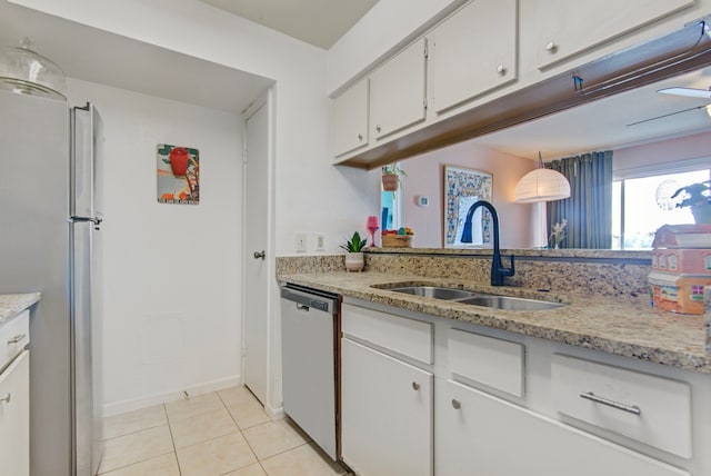 kitchen featuring stainless steel appliances, sink, light tile patterned floors, decorative light fixtures, and white cabinetry