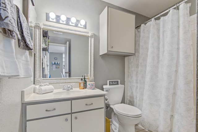 bathroom with tile patterned floors, vanity, and toilet