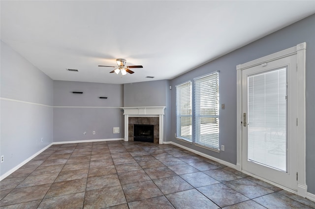 unfurnished living room featuring tile patterned flooring, ceiling fan, and a tile fireplace