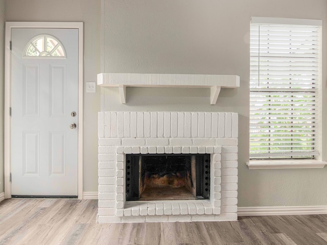 interior space featuring hardwood / wood-style flooring and a brick fireplace