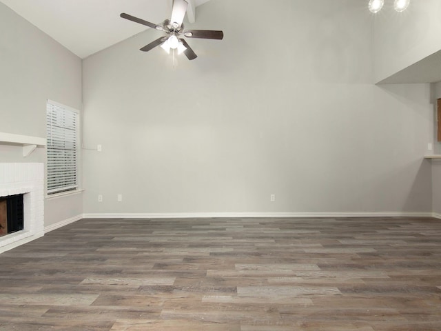 unfurnished living room featuring high vaulted ceiling, a brick fireplace, wood-type flooring, and ceiling fan