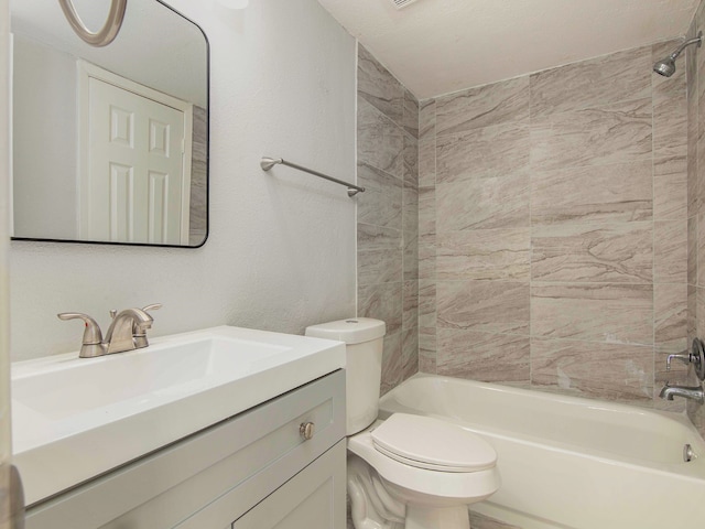 full bathroom featuring tiled shower / bath, vanity, and toilet