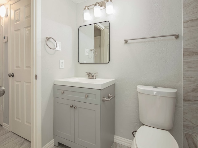 bathroom with vanity, toilet, and wood-type flooring