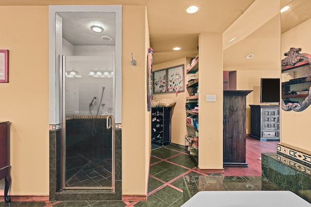 bathroom featuring a fireplace, an enclosed shower, and tile patterned floors