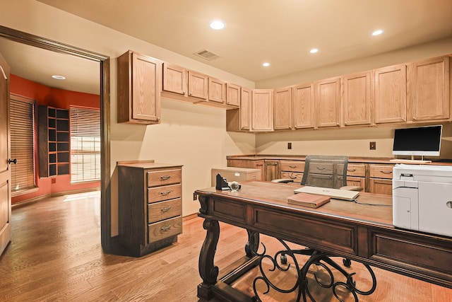 home office featuring built in desk and light hardwood / wood-style floors