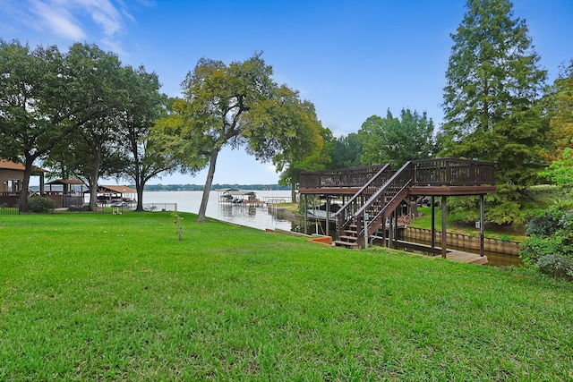 dock area featuring a lawn and a deck with water view