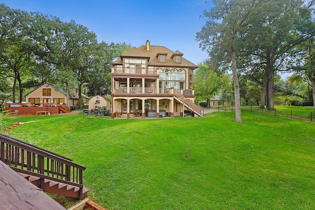 rear view of house with a lawn, a patio, and a deck