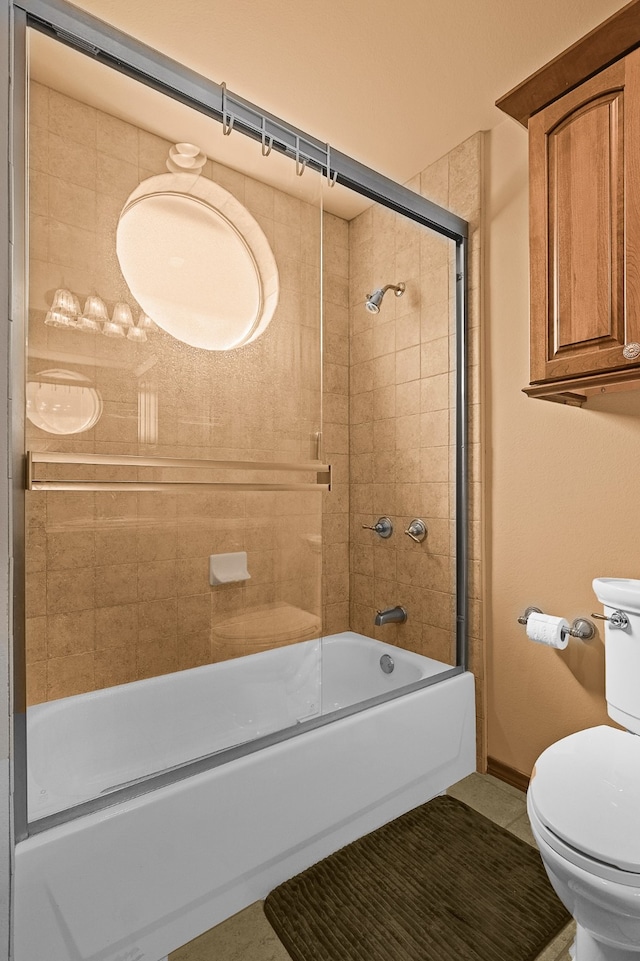 bathroom with toilet and bath / shower combo with glass door