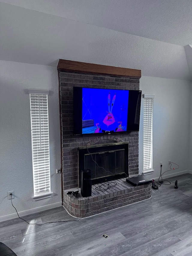 details featuring a brick fireplace, a textured ceiling, and hardwood / wood-style flooring