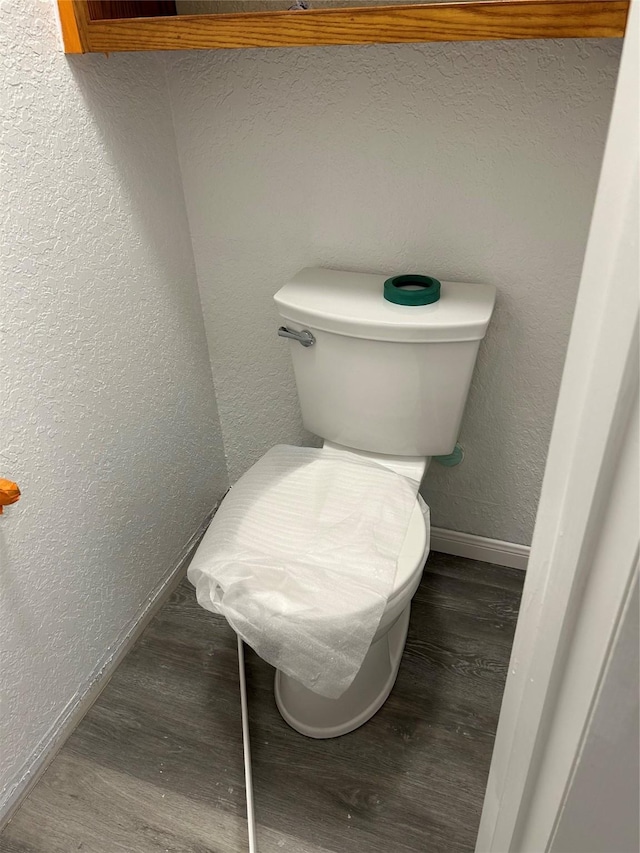 bathroom with toilet and wood-type flooring