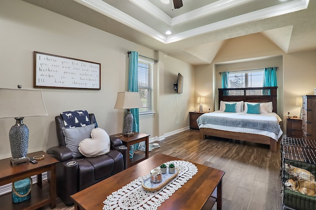 bedroom with hardwood / wood-style floors, ceiling fan, a raised ceiling, and multiple windows