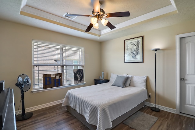 bedroom with dark hardwood / wood-style flooring, a tray ceiling, and ceiling fan