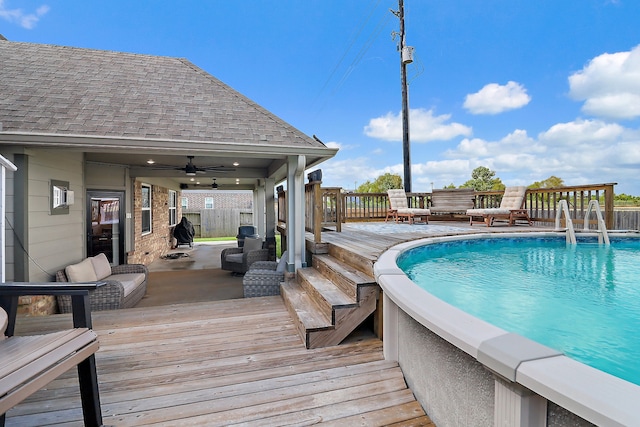 view of swimming pool featuring an outdoor living space, a deck, and ceiling fan