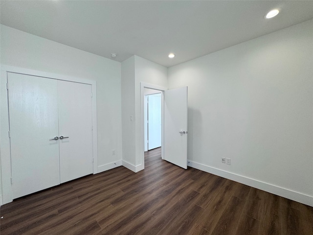 unfurnished bedroom featuring dark wood-type flooring and a closet