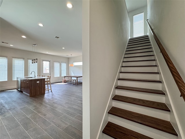 staircase with sink and wood-type flooring