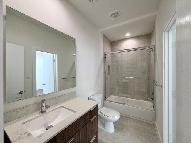 full bathroom featuring combined bath / shower with glass door, vanity, and toilet