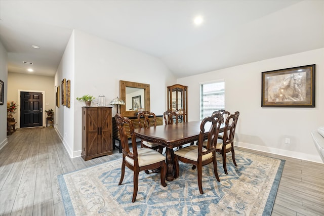 dining area with light hardwood / wood-style floors and lofted ceiling