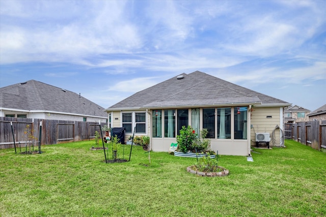 rear view of property featuring a yard and a sunroom