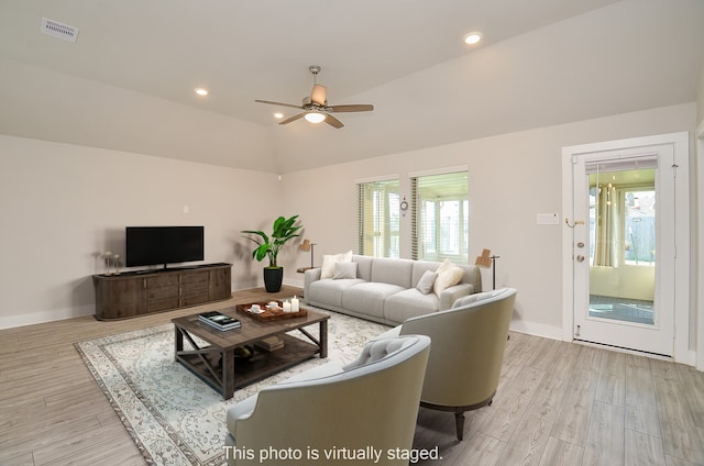 living room with ceiling fan, lofted ceiling, and light hardwood / wood-style flooring